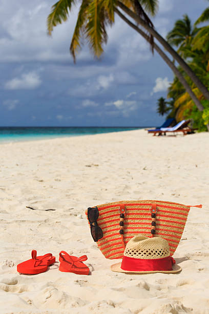 istock hat, sun glasses and flip flops on a tropical beach 506933275