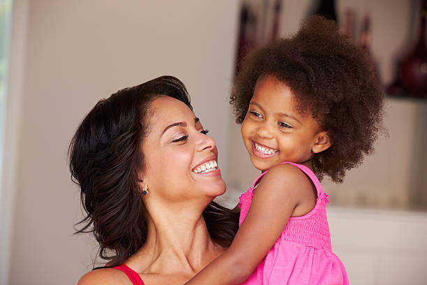 istock Mother Cuddling Daughter At Home 506933305