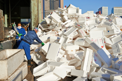 Tokyo, Japan - March 08, 2014: two japanese workers collect styrofoam boxes at a recycling center at Tsukiji Fish Market.