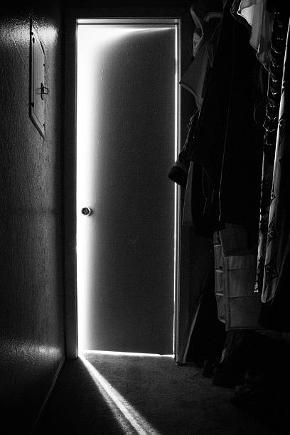 Door, Ajar A view from inside a closet with the door slightly cracked open. ajar stock pictures, royalty-free photos & images