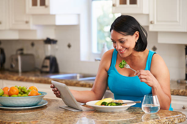 Overweight Woman With Digital Tablet Checking Calorie Intake