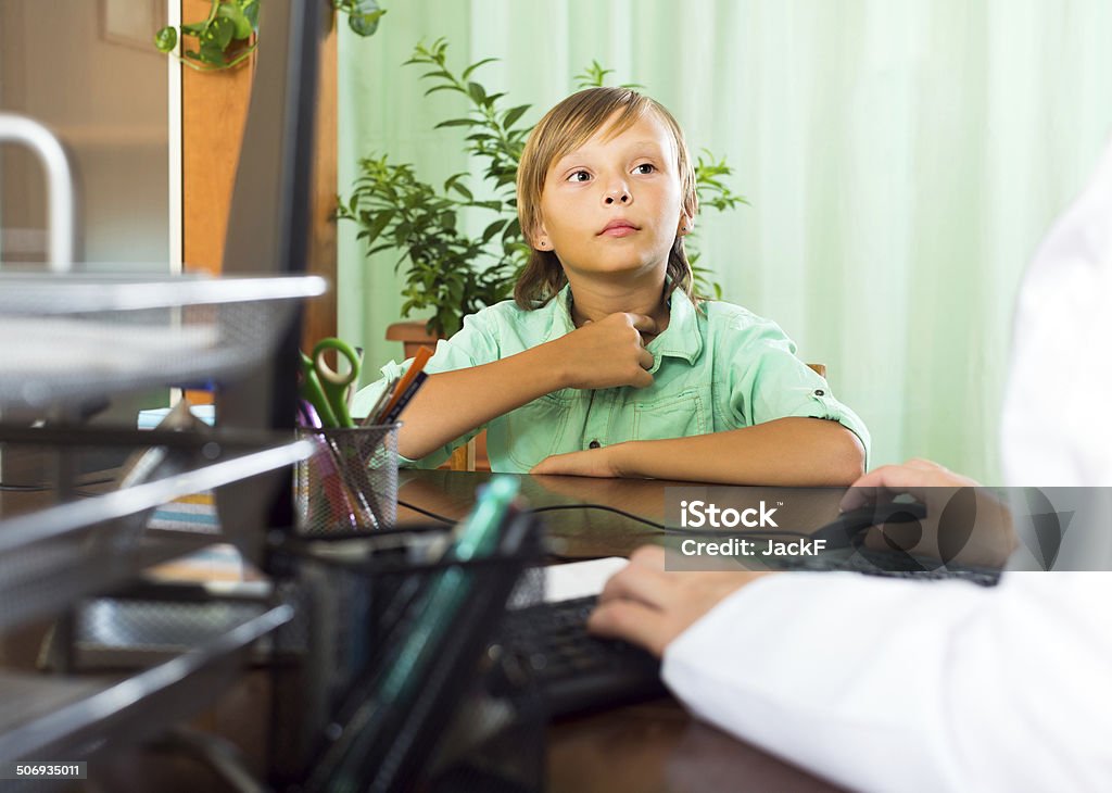 Doctor with teenager patient Schoolboy complaining of pain in throat to doctor in clinic 10-11 Years Stock Photo