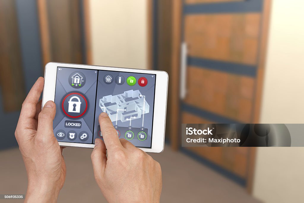 Smart home automation: locking house door with security remote control Smart home automation: hand pointing an interactive tablet display showing door automatic locking system, with safety icons and symbols and unlocking functions. Technology Stock Photo