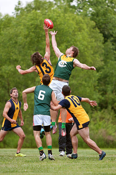 мужчины прыжки на мяч в любительский австралийский футбол игра - playing field effort outdoors human age стоковые фото и изображения