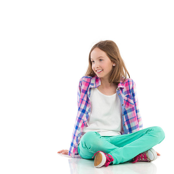 niña sonriente sentado con las piernas cruzadas - sentado en el suelo fotografías e imágenes de stock
