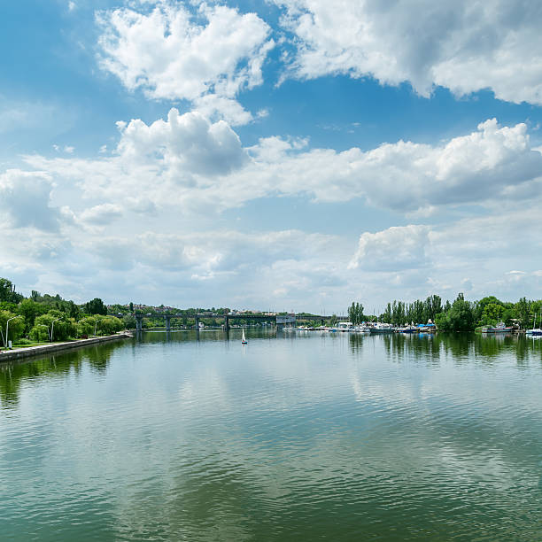 vue sur la rivière et nuages dans le ciel bleu - horizon over water white green blue photos et images de collection