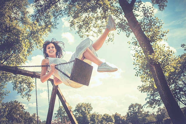 istock Happy young woman having fun on the swing 506974731