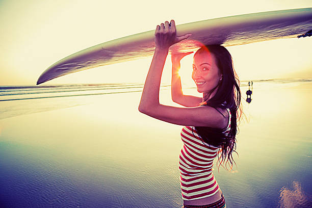 istock Young woman with surf board on the beach 506975187