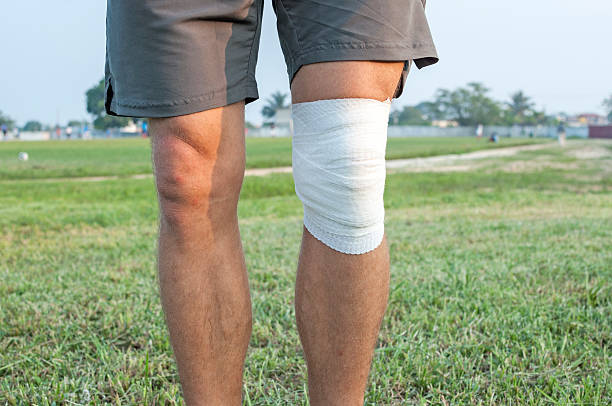 avvolgere per infortunio al ginocchio di sport - human knee physical injury bandage muscular build foto e immagini stock