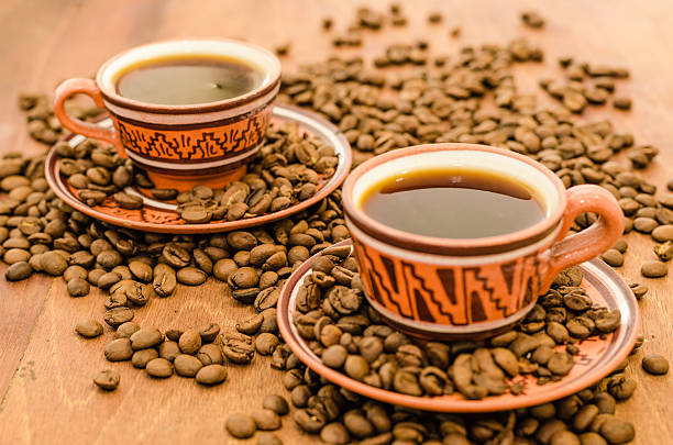 Coffee with steam, grains on a wooden table stock photo