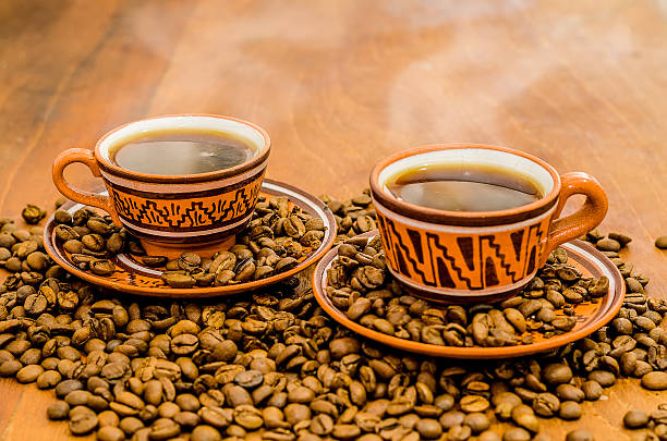 Coffee with steam, grains on a wooden table stock photo
