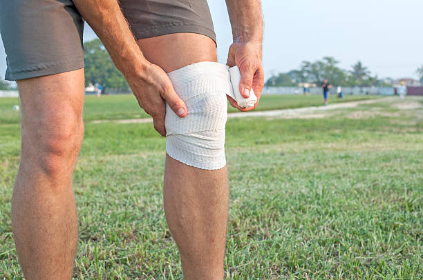 confezione infortunio al ginocchio - human knee physical injury bandage muscular build foto e immagini stock