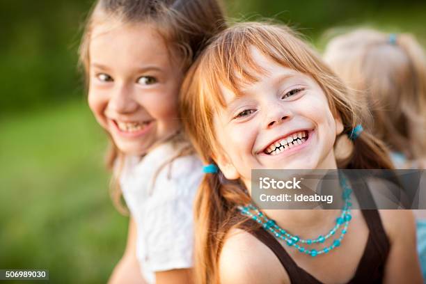 Three Happy Sisters Laughing While Sitting Together Outside Stock Photo - Download Image Now