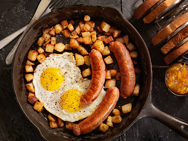 завтрак с глазунья яйца и сосиски - sunnyside стоковые фото и изображения