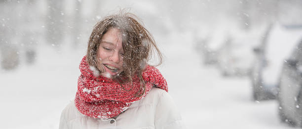 teenager-mädchen unter schneefall auf der straße - queens head stock-fotos und bilder