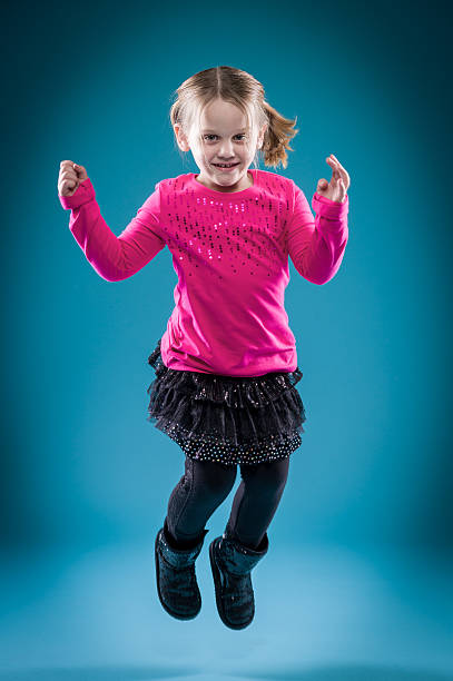 istock Little girl jumping on blue background 506994106