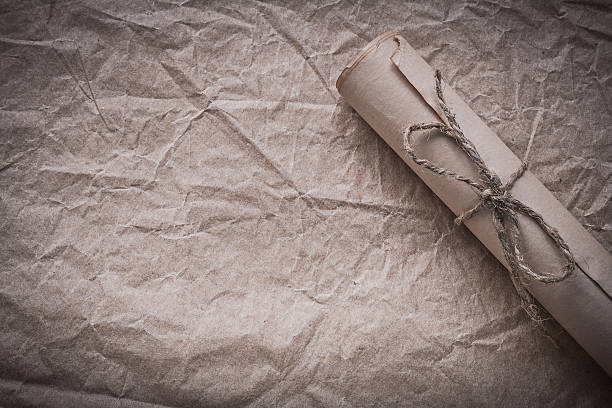 istock Vintage rolled paper on crumpled wrapping sheet 506995208