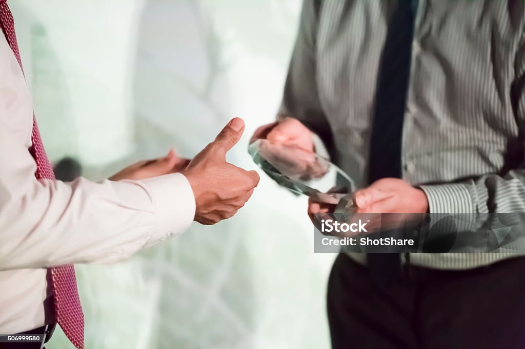 Award ceremony Unrecognizable man is greeting colleague with an award, selective focus  Award Stock Photo