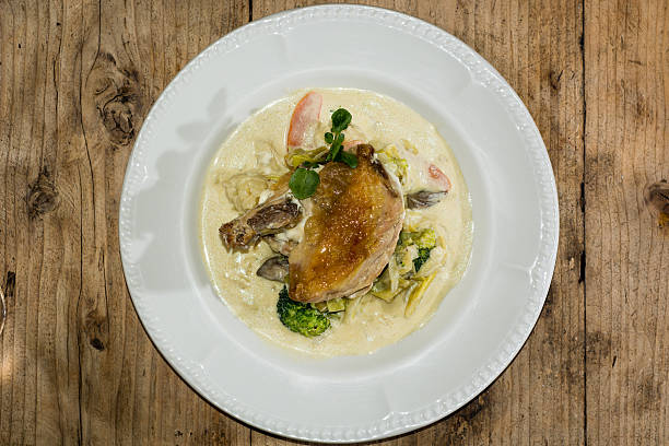 Guinea fowl breast, mustard sauce and mixed vegetables Classic French dish presented on a white plate on top of vegetables, from above guinea fowl stock pictures, royalty-free photos & images