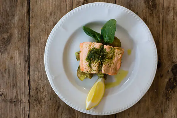 Photo of Salmon fillet, pesto and crushed potato from above
