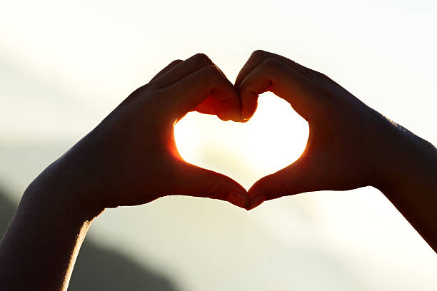 istock Hands forming a heart shape at sunset with mountains background. 507003228