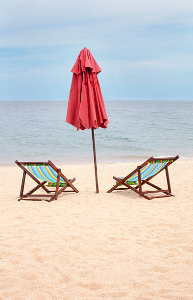 istock Beach chairs and an umbrella on an empty beach 507005227