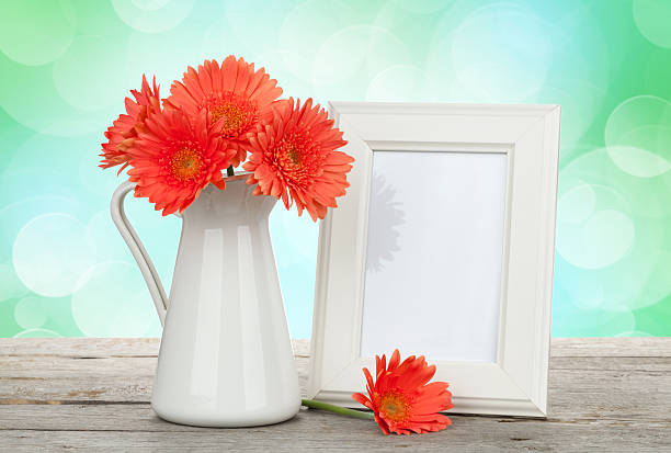 istock Orange gerbera flowers and photo frame on wooden table 507008143