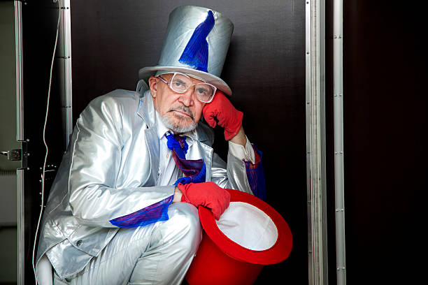 Magician sitting in a box Magician in a white suit with hat sitting in a box before the show pantomime dame stock pictures, royalty-free photos & images
