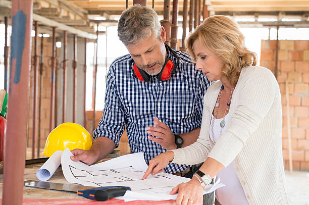 Two People Discussing Plan Project Portrait Of Male Architect And Mature Woman Discussing Plan On Blueprint At Construction Site sign human hand pointing manual worker stock pictures, royalty-free photos & images