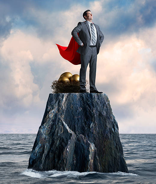 istock Businessman Stands While Protecting His Nest Egg On Isolated Island 507022082