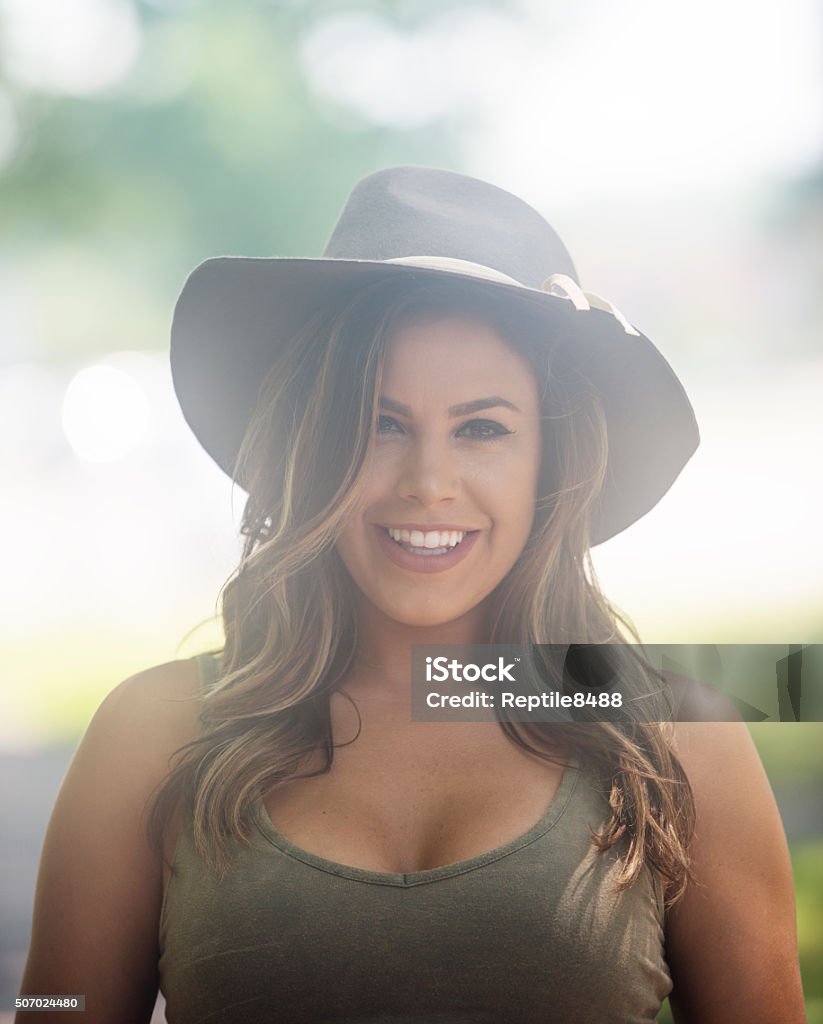 Young woman at a park Confident and beautiful young female  in a park and enjoying the day.Confident and beautiful young female  in a park and enjoying the day. Cowgirl Stock Photo