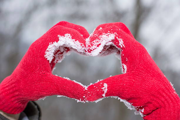 istock red woolen glooves making a heart shape in snow 507029472