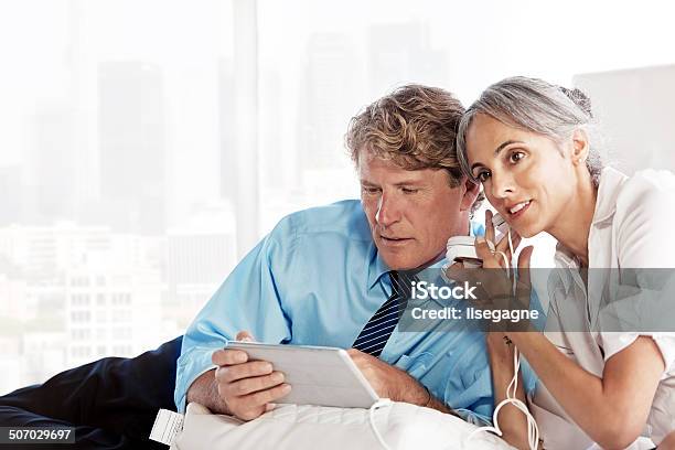 Business Couple Using A Digital Tablet Stock Photo - Download Image Now - 50-59 Years, Adult, After Work