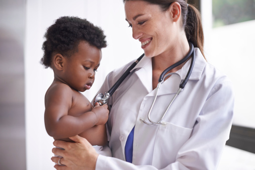 An attractive female pediatrician doing a checkup on an adorable baby boy