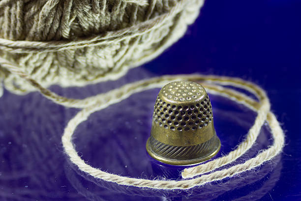 istock Ball of gray thread and thimble 507030890