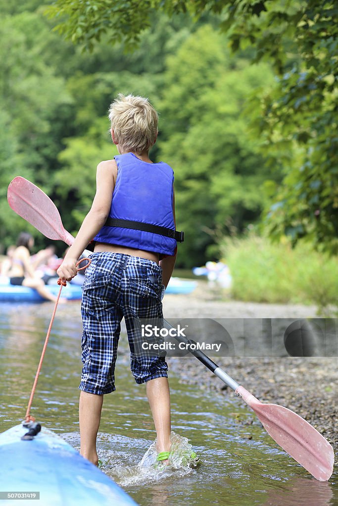 Active boy enjoying kayaking on the river during summer camp Active happy child, teenage school boy, having fun enjoying adventurous experience kayaking on the river on a sunny day during summer vacation Boys Stock Photo