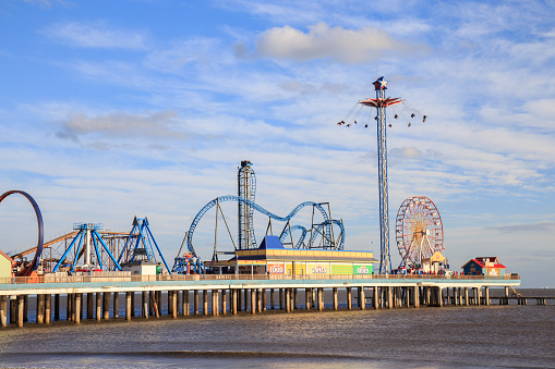 Galveston, USA - January 10, 2016: Historic Pleasure Pier amusement park and beach on the Gulf of Mexico coast in Galveston, Texas.