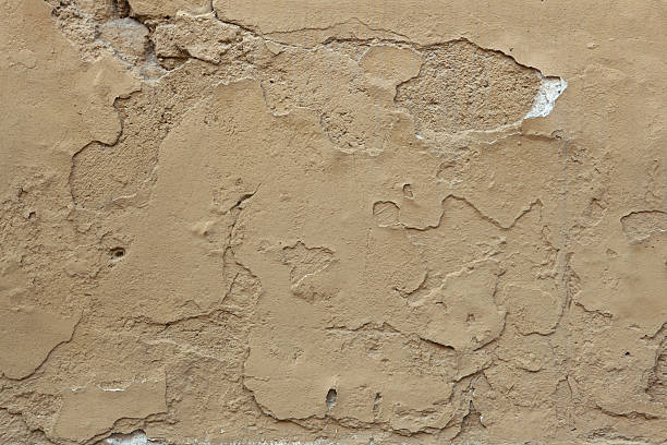 istock Old ochre painted stucco wall with cracked plaster. Background t 507033168