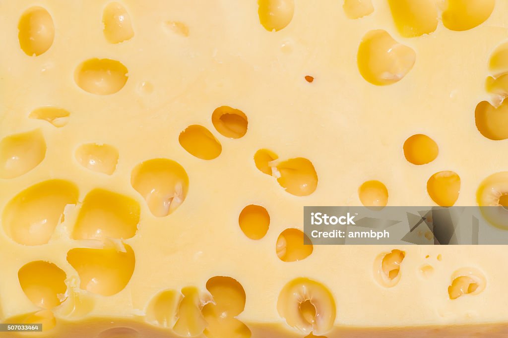 Texture of Swiss-type cheese with cheese's eyes Texture of the medium-hard Swiss cheese with large cheese's eyes closeup Agriculture Stock Photo