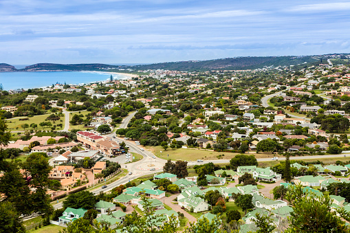 Plettenberg Bay and luxury homes seen from the cliff above, with the bay and beach towards the left. This is a favourite holiday destination along the Garden Route in the Western Cape Province of South Africa.
