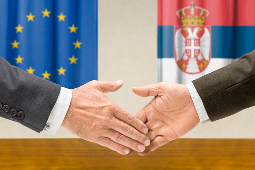 Representatives of the EU and Serbia shake hands
