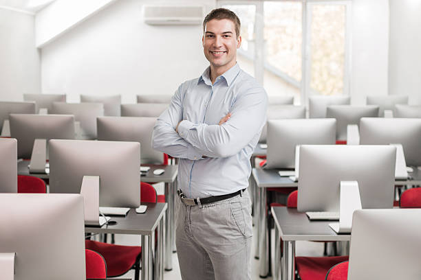 istock Smiling businessman with arms crossed in computer lab. 507037560