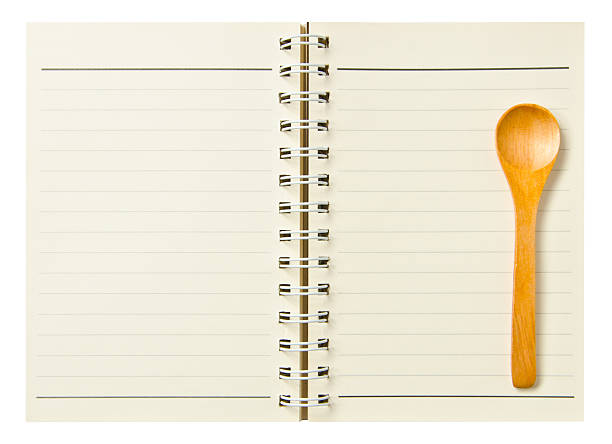 istock spoon wooden on notebook isolated on white background. 507059537