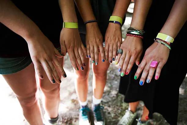 Cropped image of a group of young girl's hands and their colourful nails