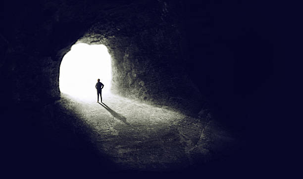 Finding the light A shot of someone finding an exit from a dark tunnel - ALL design on this image is created from scratch by Yuri Arcurs'  team of professionals for this particular photo shoot light at the end of the tunnel photos stock pictures, royalty-free photos & images