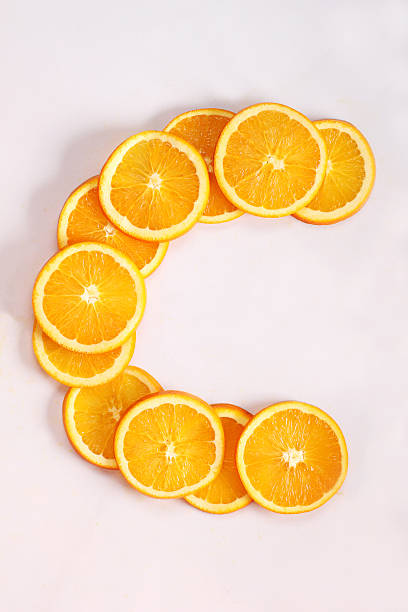 sliced fresh oranges arranged in c shape sliced fresh oranges arranged in c shape on white background vitamin c stock pictures, royalty-free photos & images