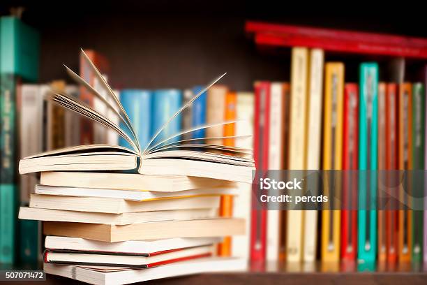 Stack Of Books On A Shelf Multicolored Book Spines Stock Photo - Download Image Now