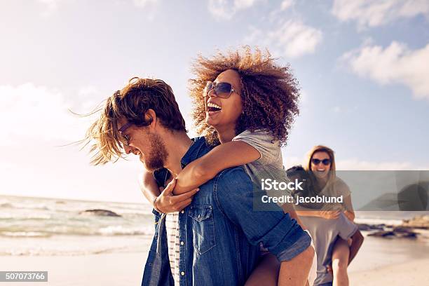 Jóvenes Amigos Disfrutando De Un Día En La Playa Foto de stock y más banco de imágenes de Amistad - Amistad, Playa, Verano