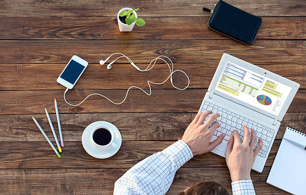 istock Man working on Computer at wooden Desk overhead View 507078838