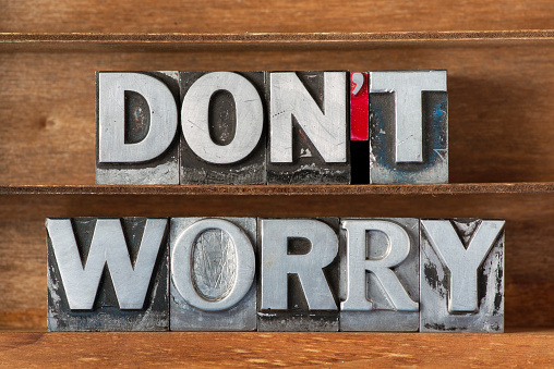 don’t worry phrase made from metallic letterpress type on wooden tray